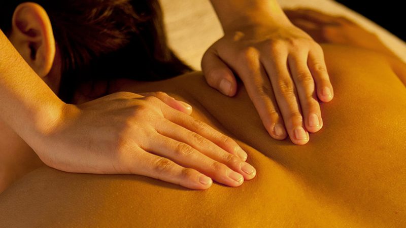 hands on a woman's back performing a massage